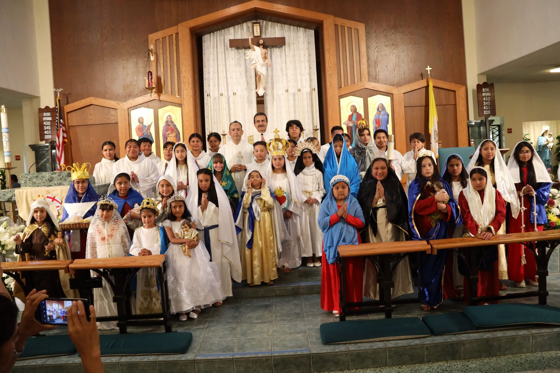Group posing inside a church sanctuary with a crucifix and altar in the background