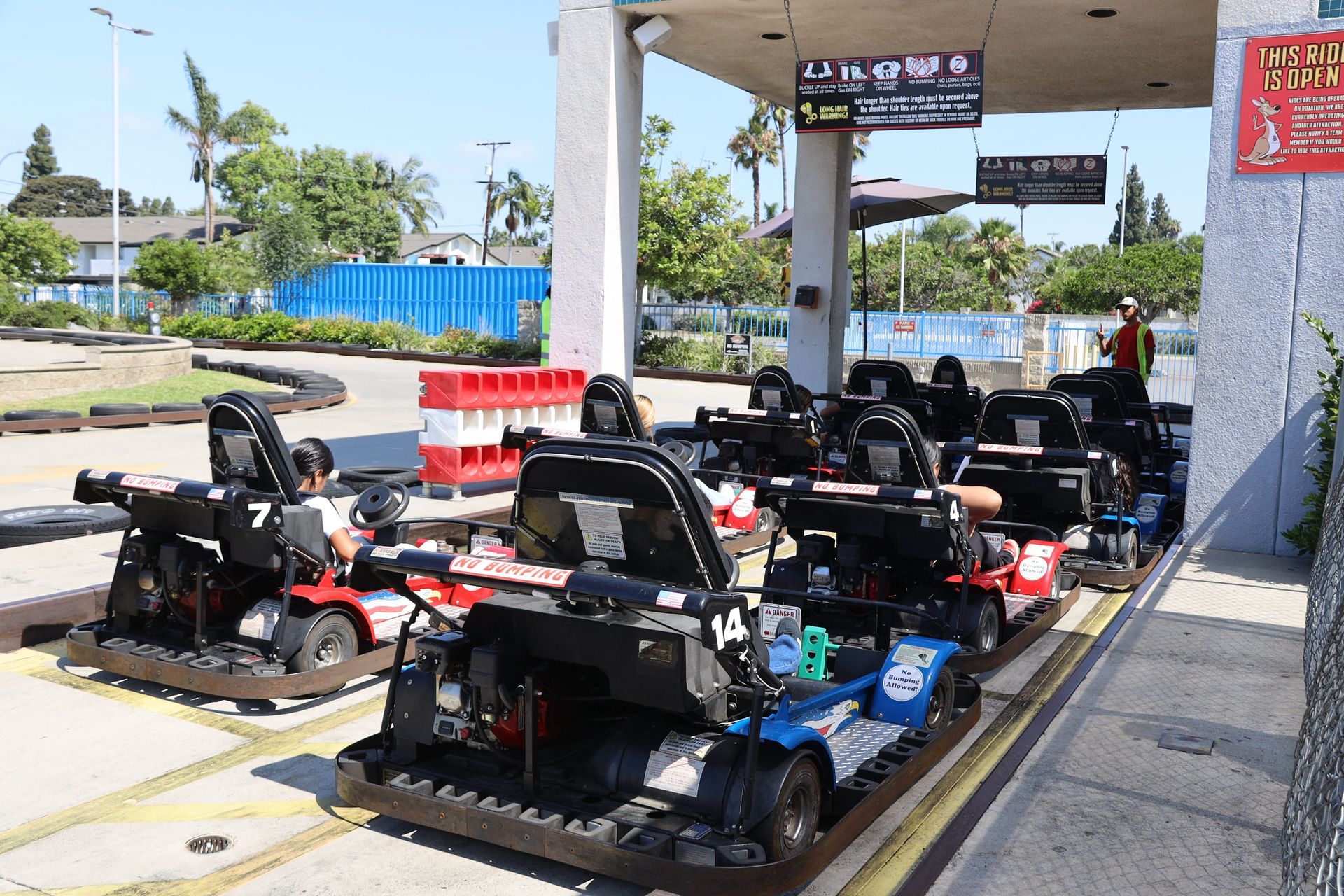 Row of black and red go-karts parked under a covered outdoor track area