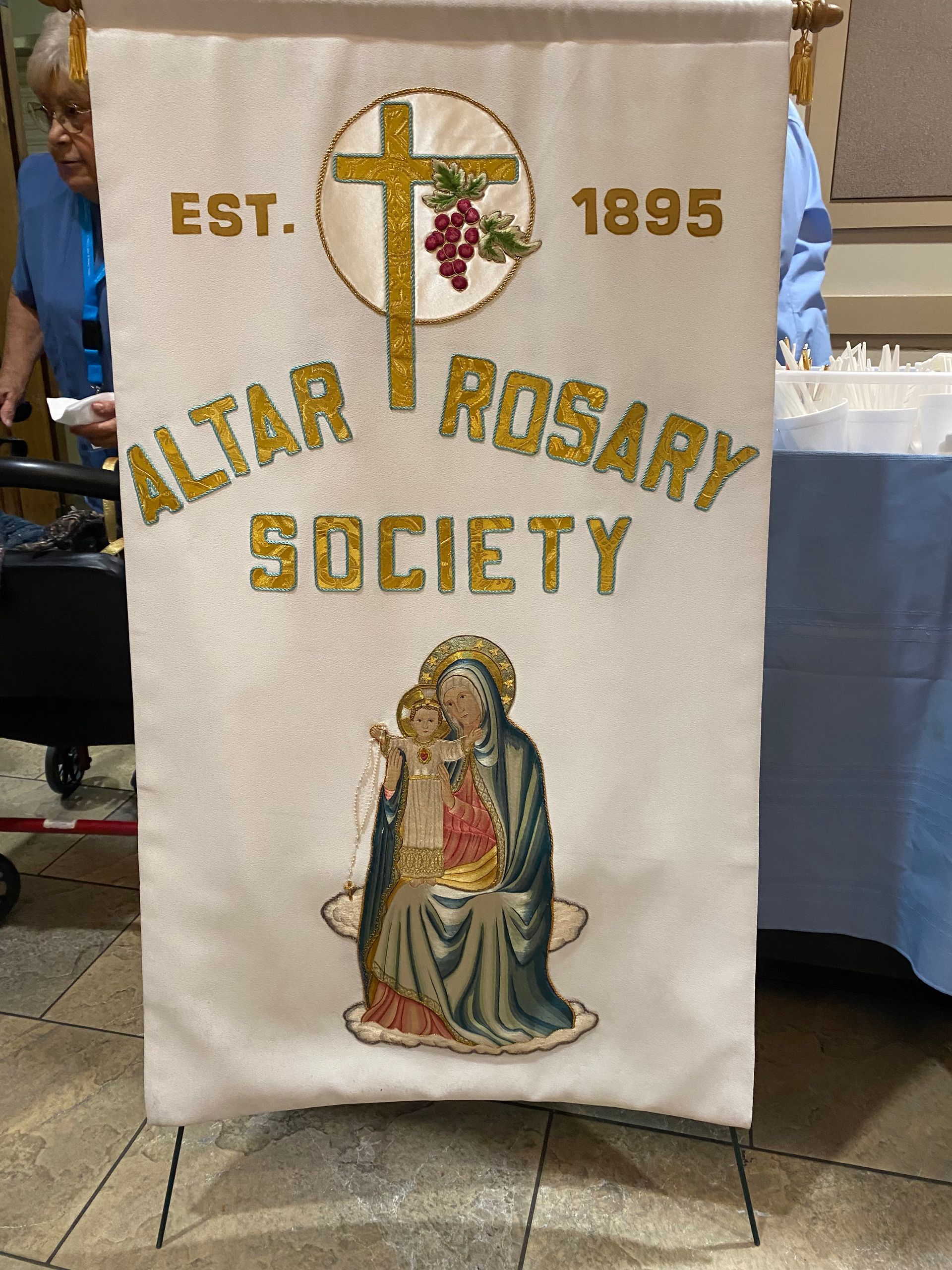 Altar Rosary Society banner with cross, rosary, and Virgin Mary on white cloth
