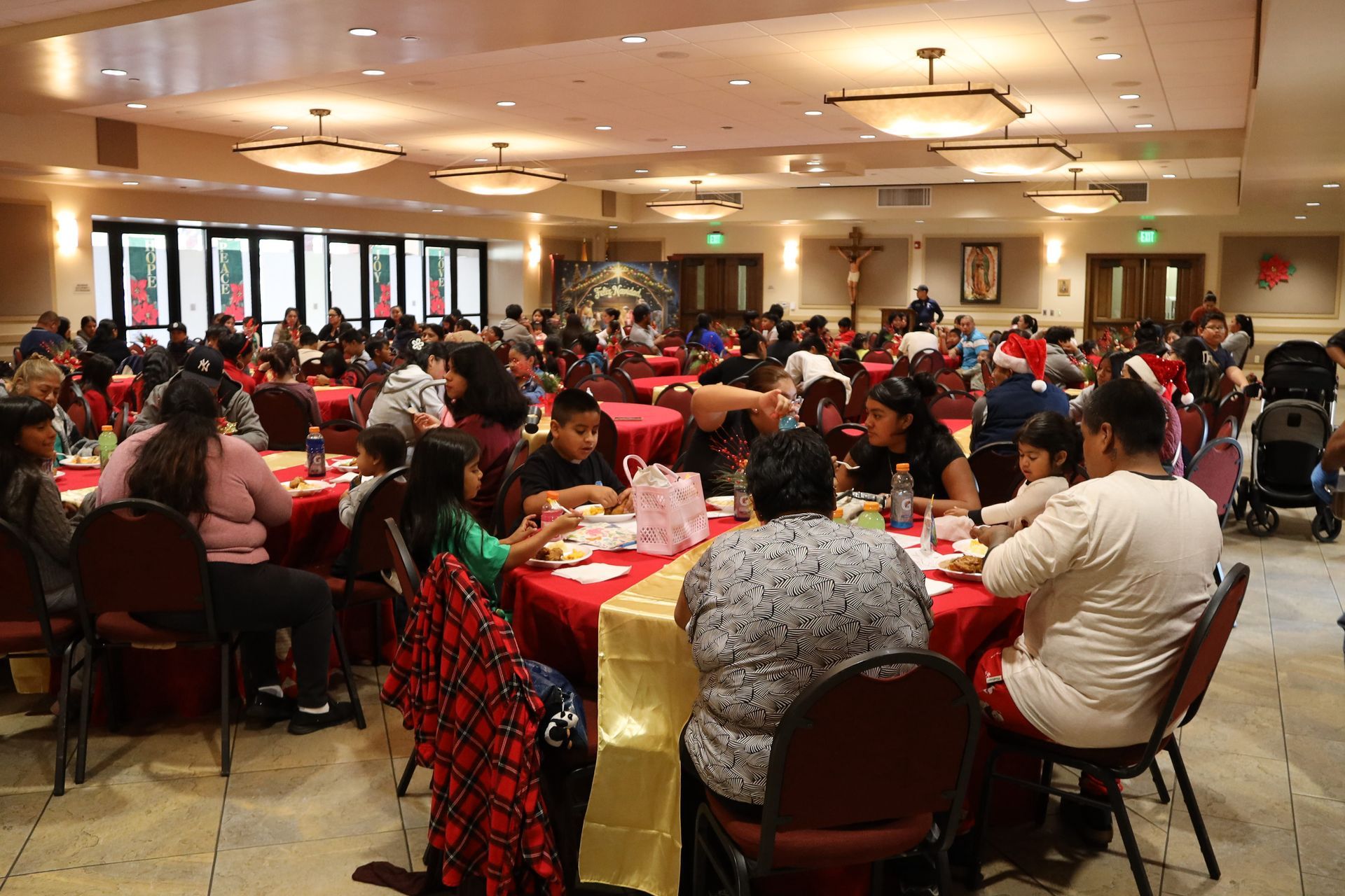 Large banquet hall filled with people seated at round tables for a crowded meal or event
