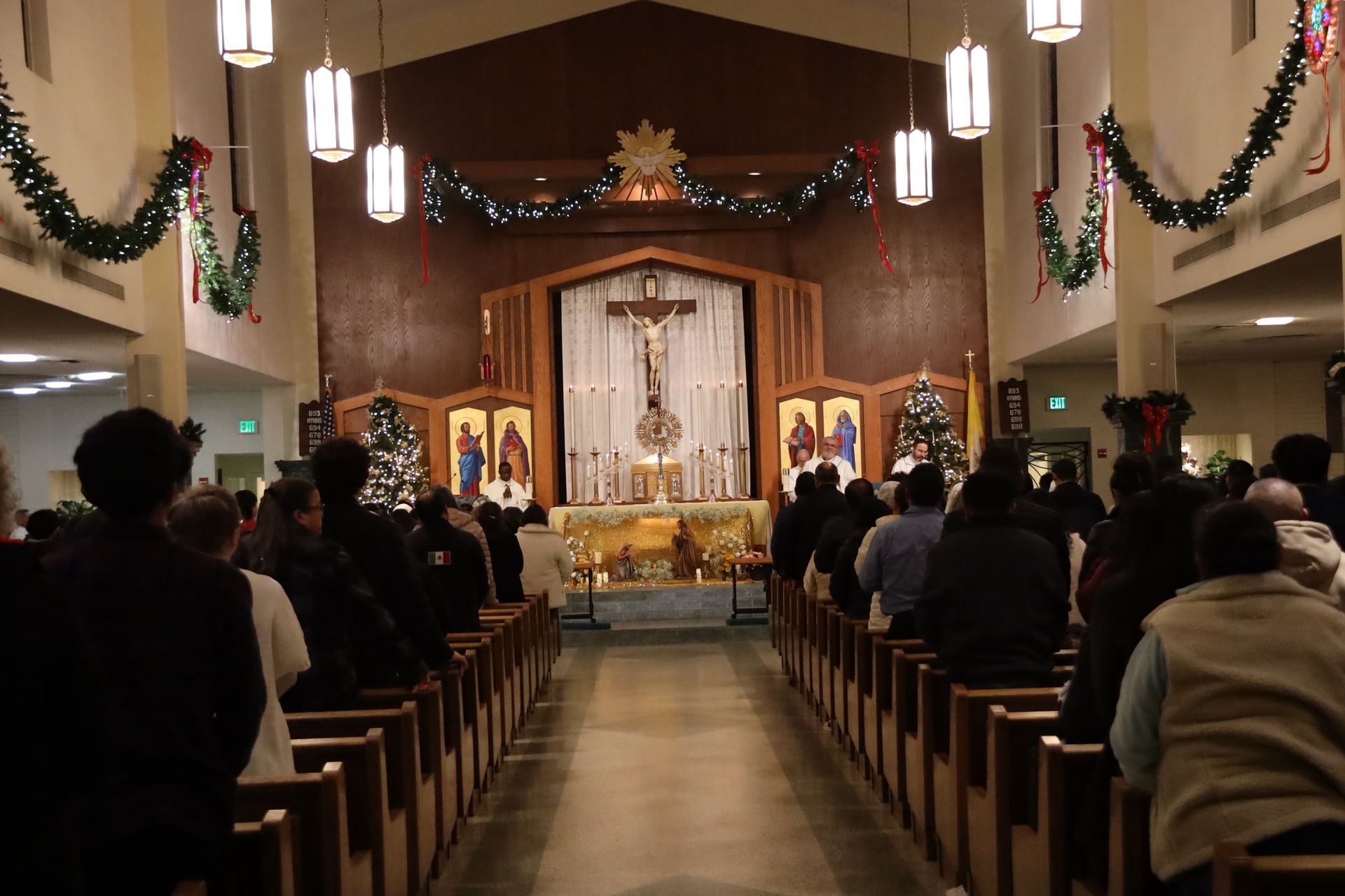 Church congregation standing in pews facing a decorated altar during a service