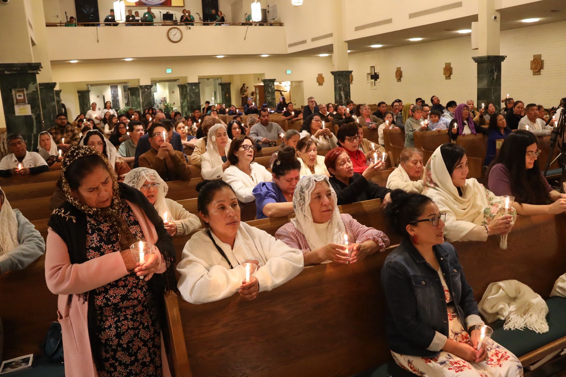 Audience seated in a church or auditorium, many clapping during a gathering
