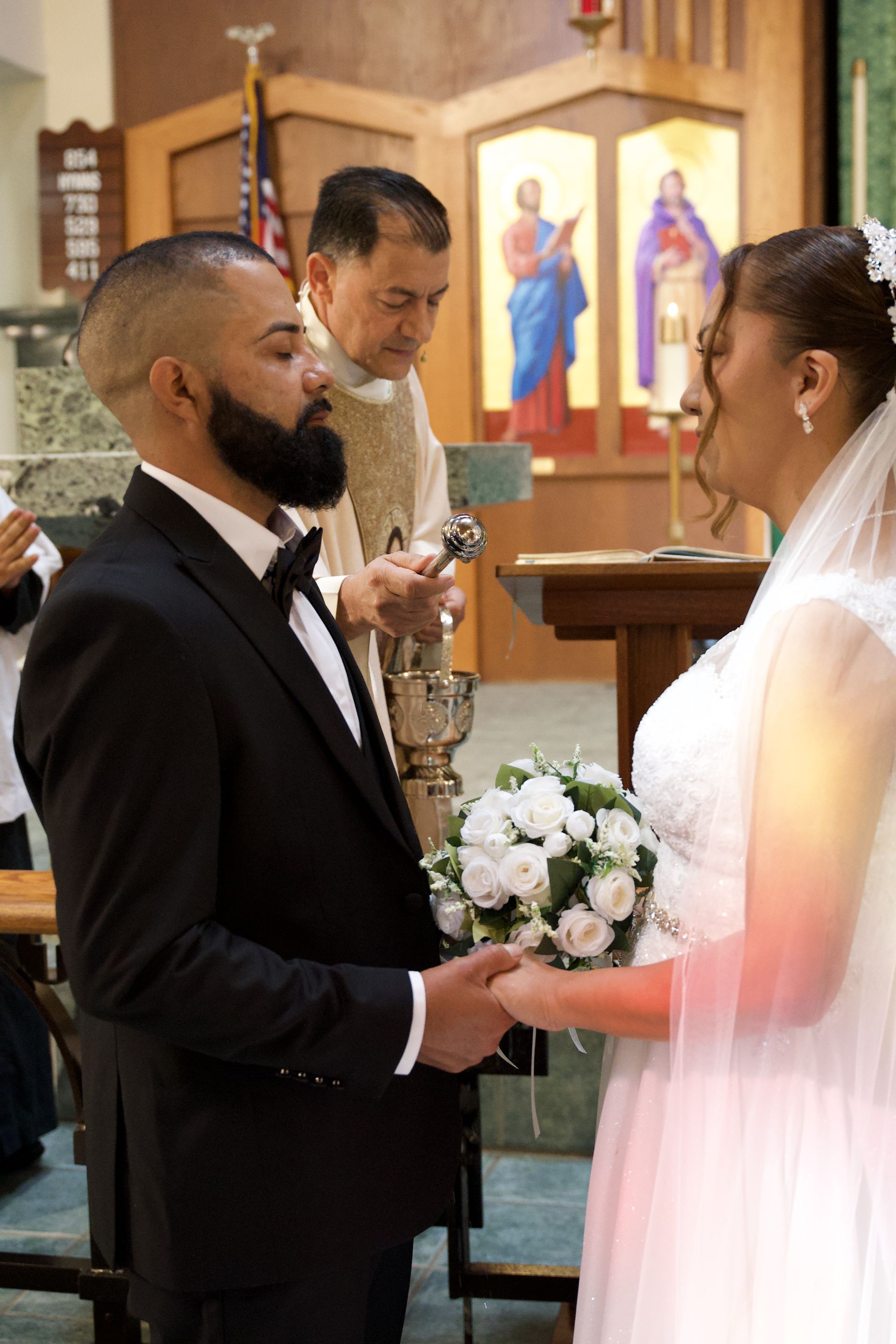 Bride and groom exchanging vows in a church, holding a bouquet and ring during the ceremony