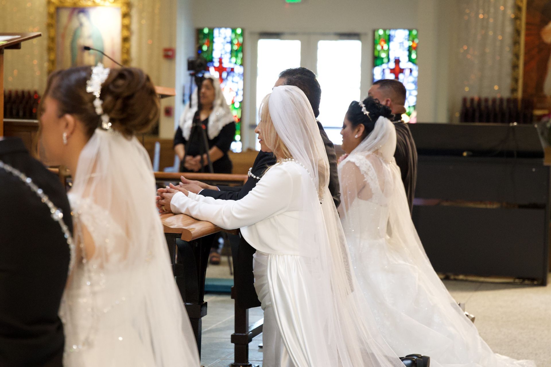 Brides in white veils play a grand piano during a church wedding ceremony