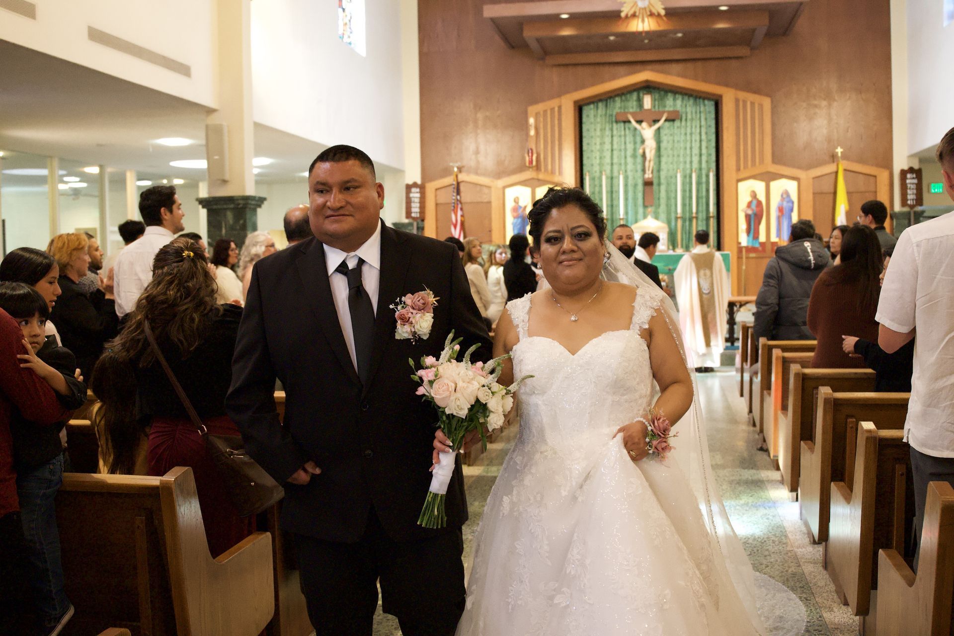 Bride and groom walk down church aisle after wedding ceremony