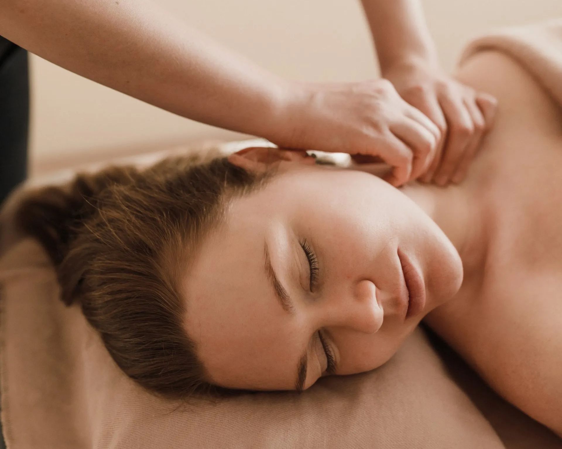 Eine Frau liegt auf einem Bett und bekommt eine Massage.