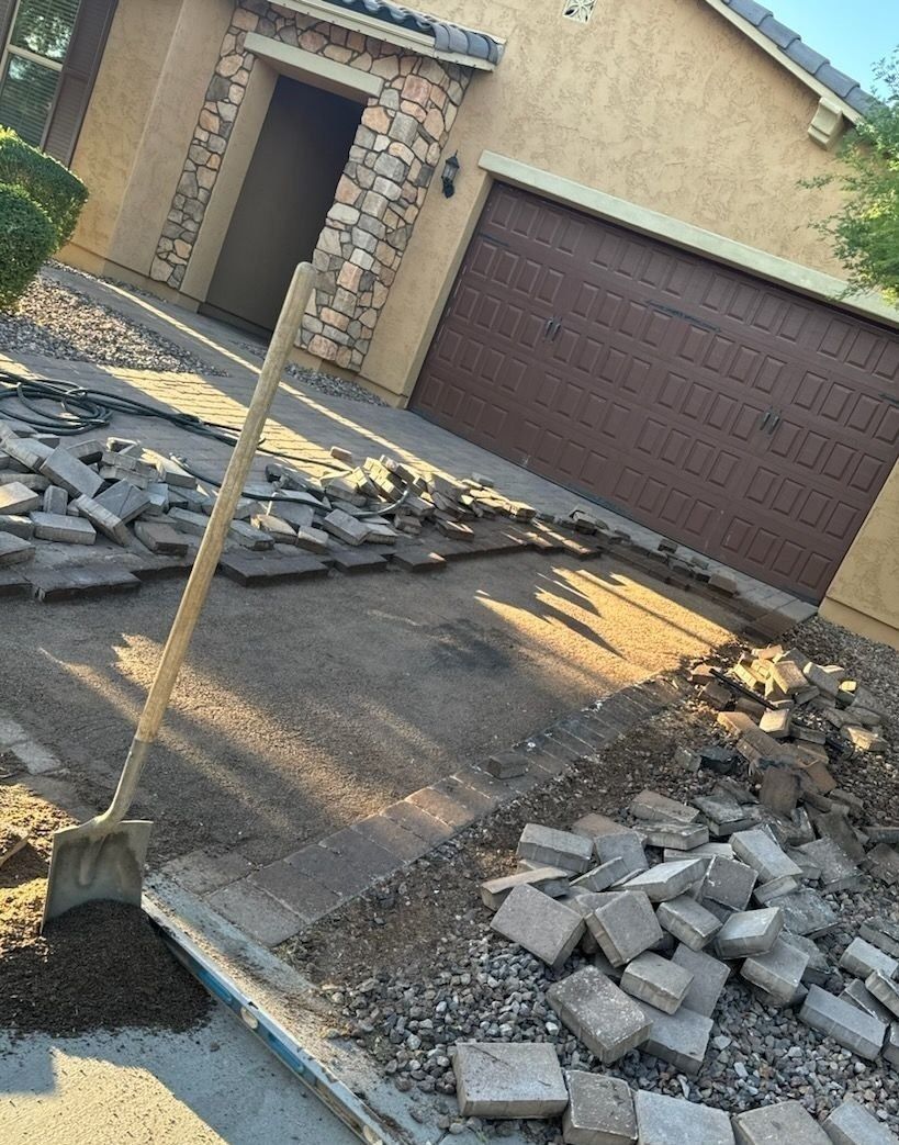 A shovel is laying on the ground in front of a house.