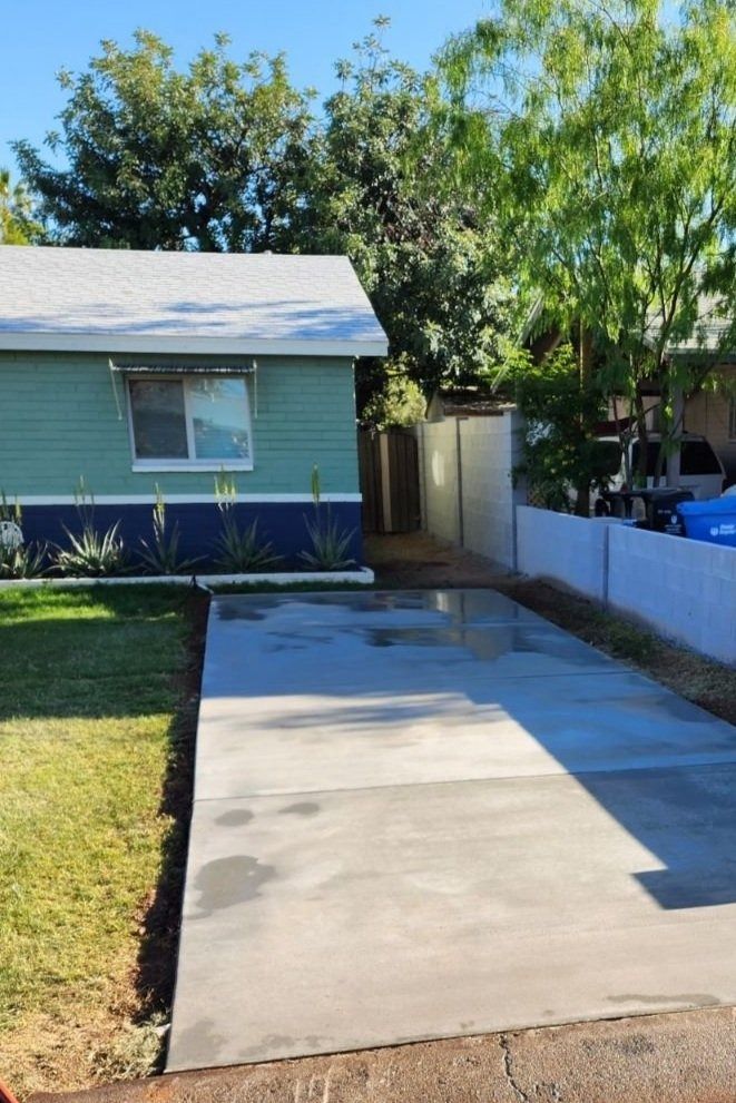 A house with a concrete driveway in front of it