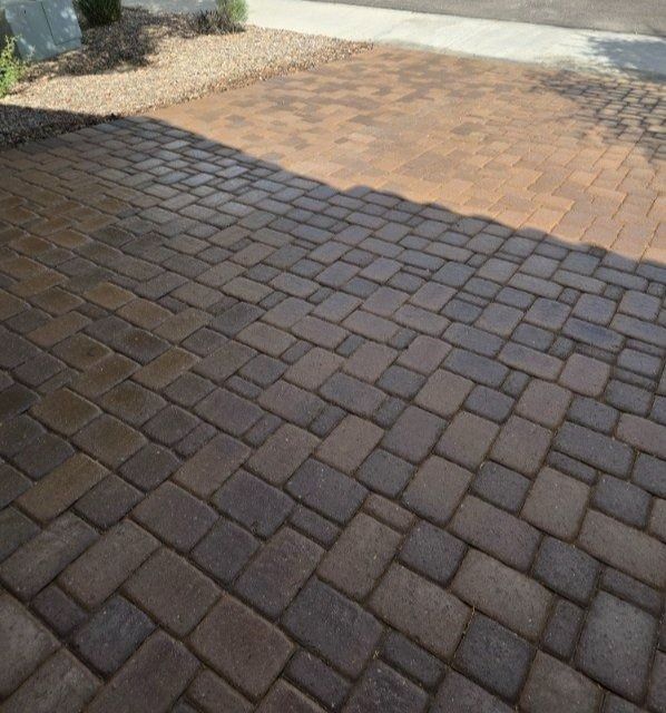 A brick driveway with a shadow on the ground