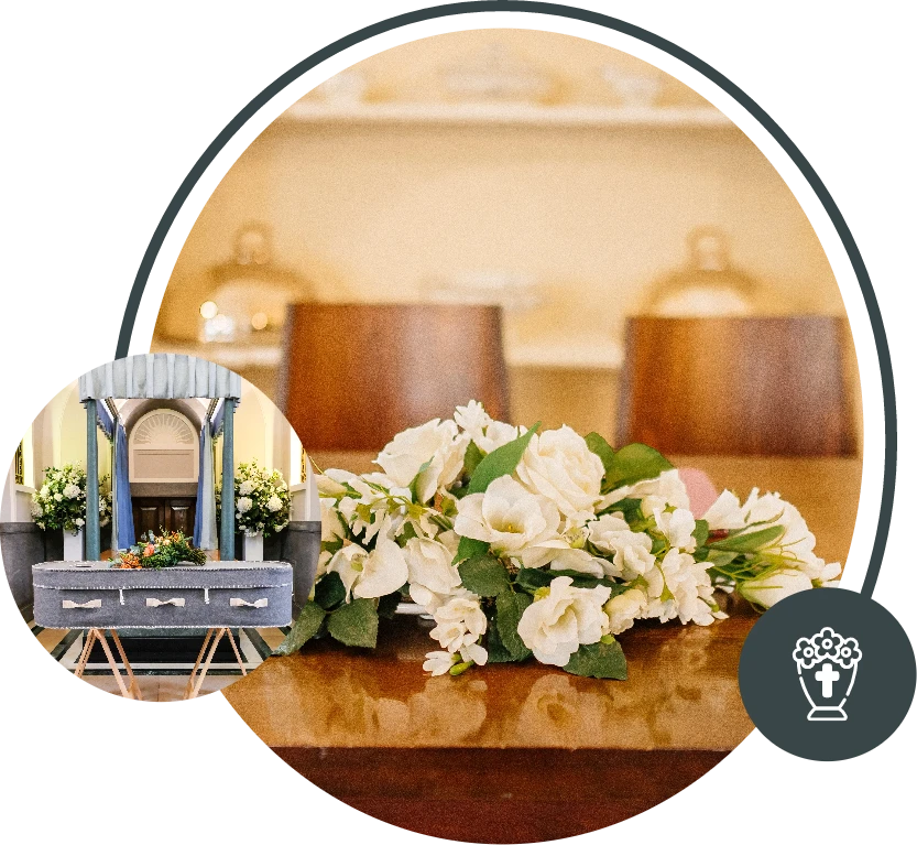 White floral funeral arrangement on a wooden table in a warm indoor setting