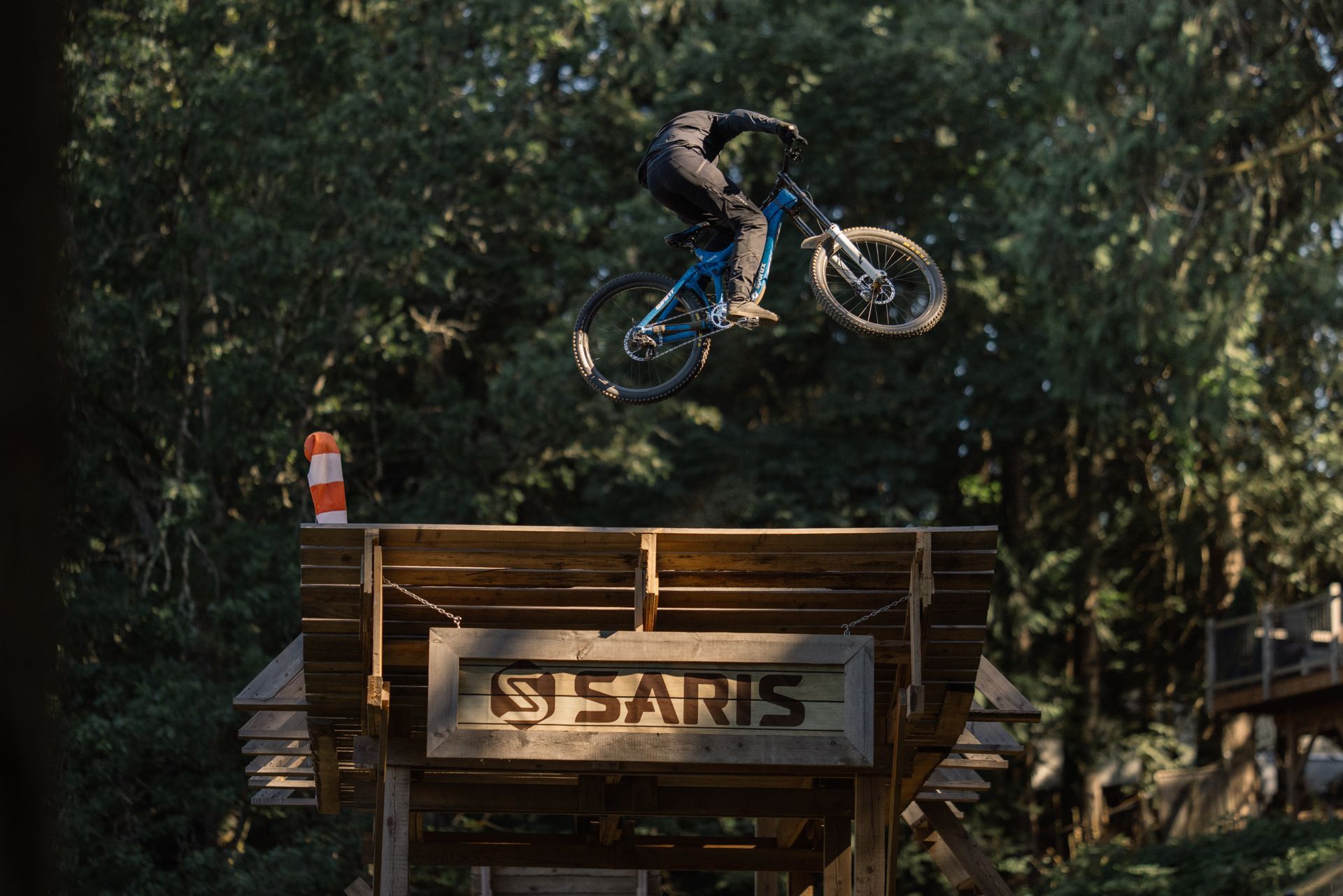 Mountain biker in mid-air over a wooden jump with a 
