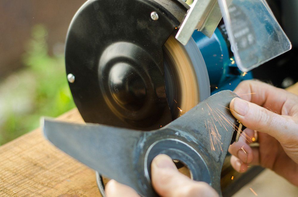 Worker Sharpening His Blade Lawn Mower — The Saw Spot In Kyogle NSW