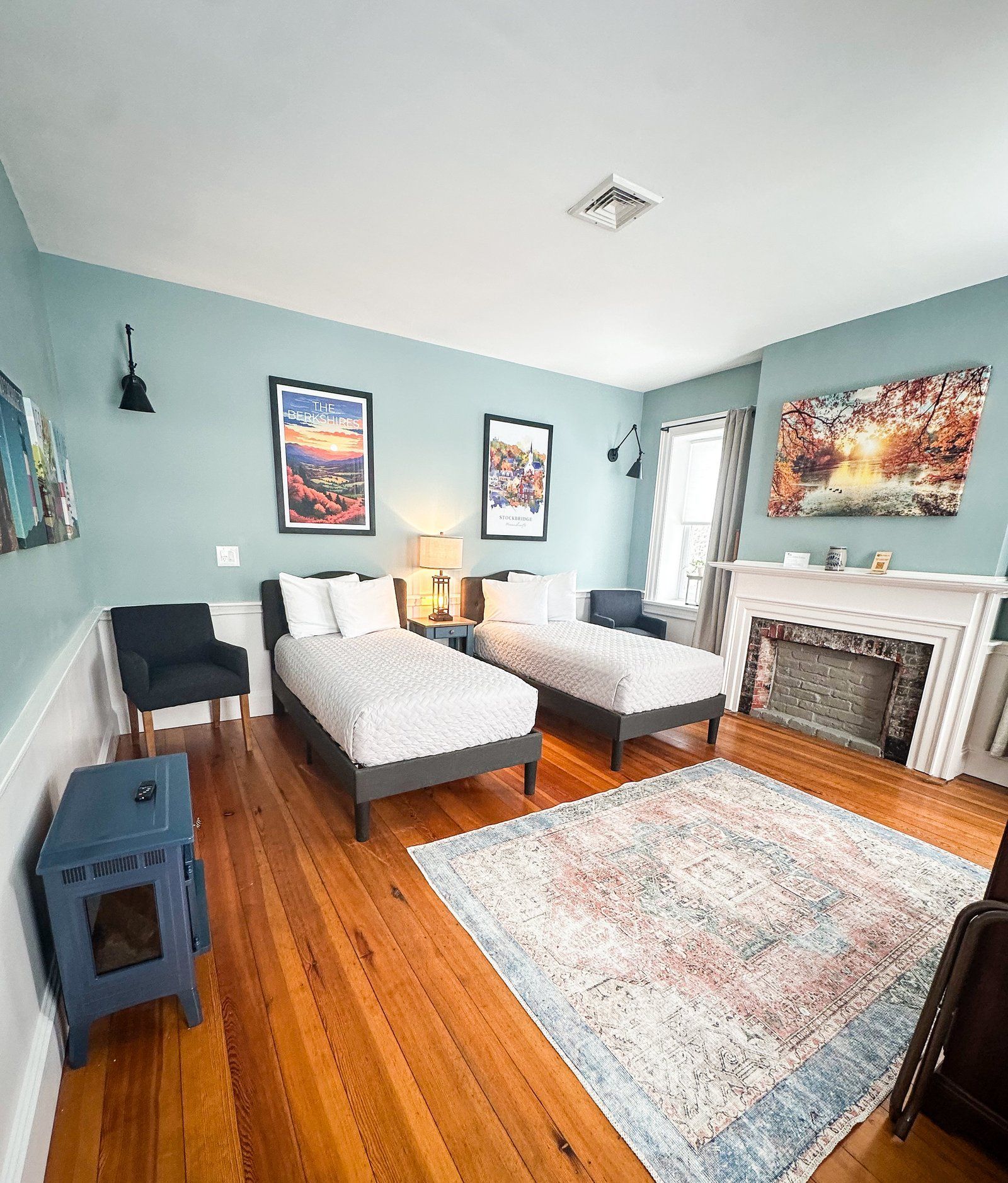 A bedroom with two twin beds and a fireplace.