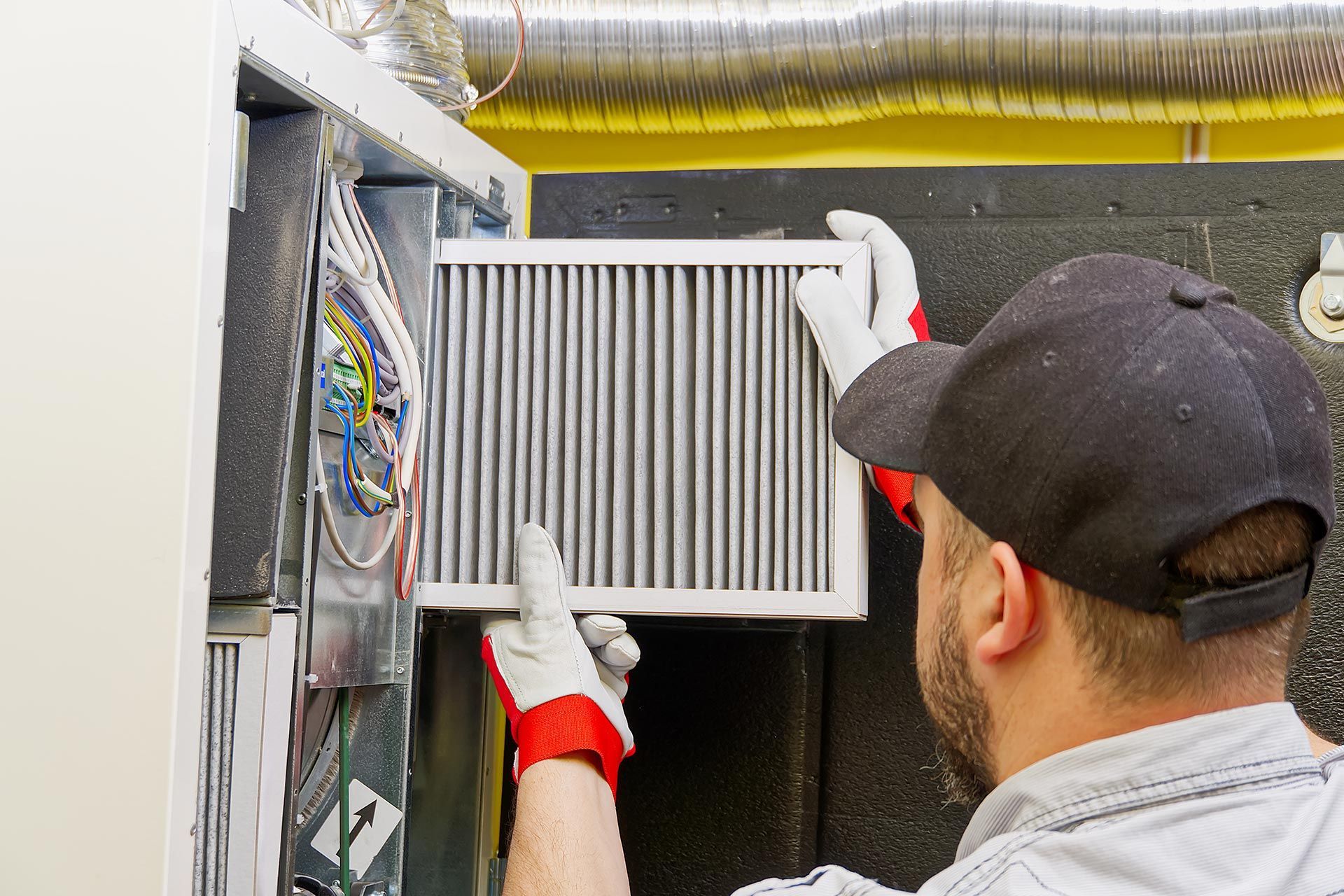 Technician changing dirty air filter in the central ventilation system.