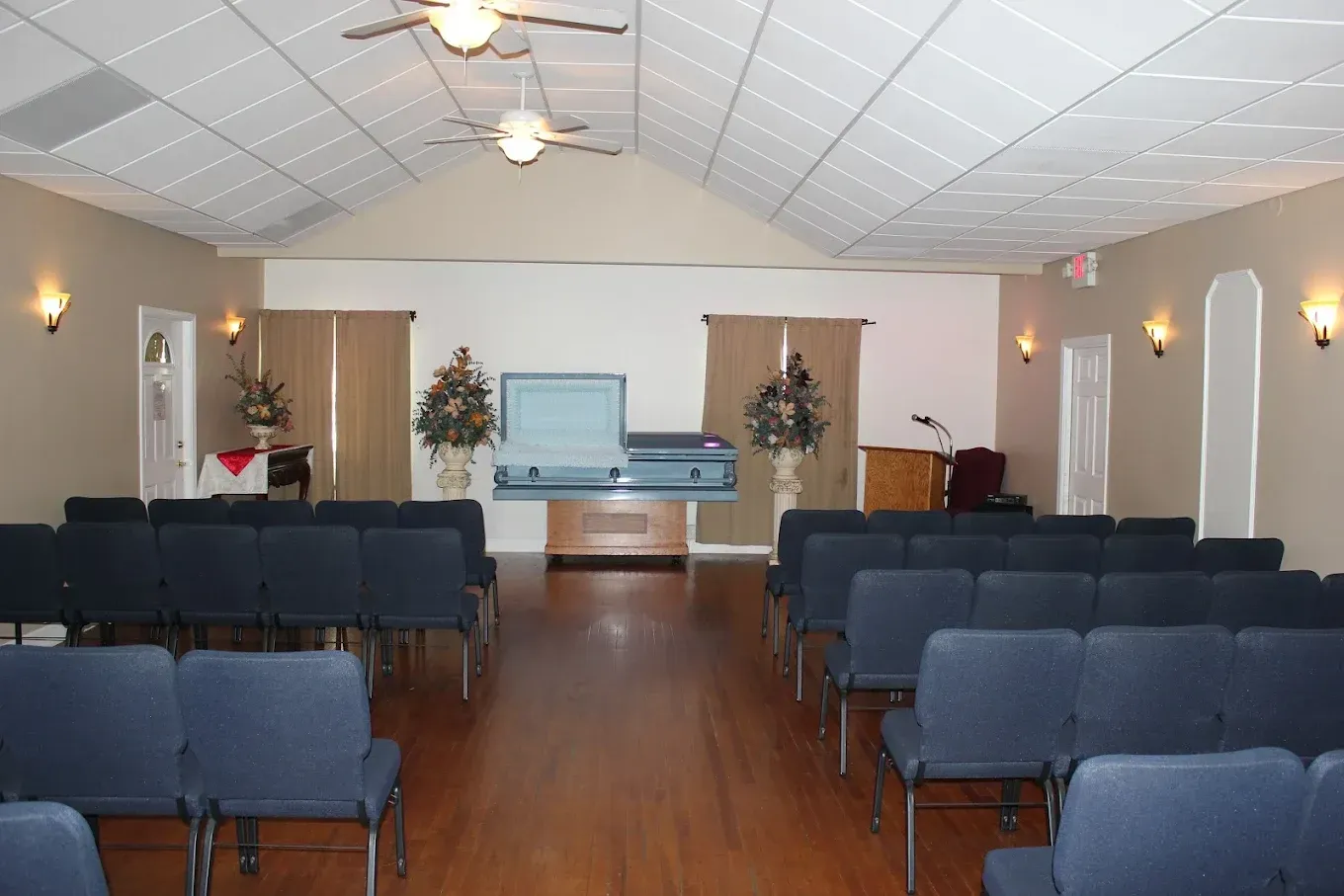 Empty church sanctuary with rows of blue chairs facing an altar at the front