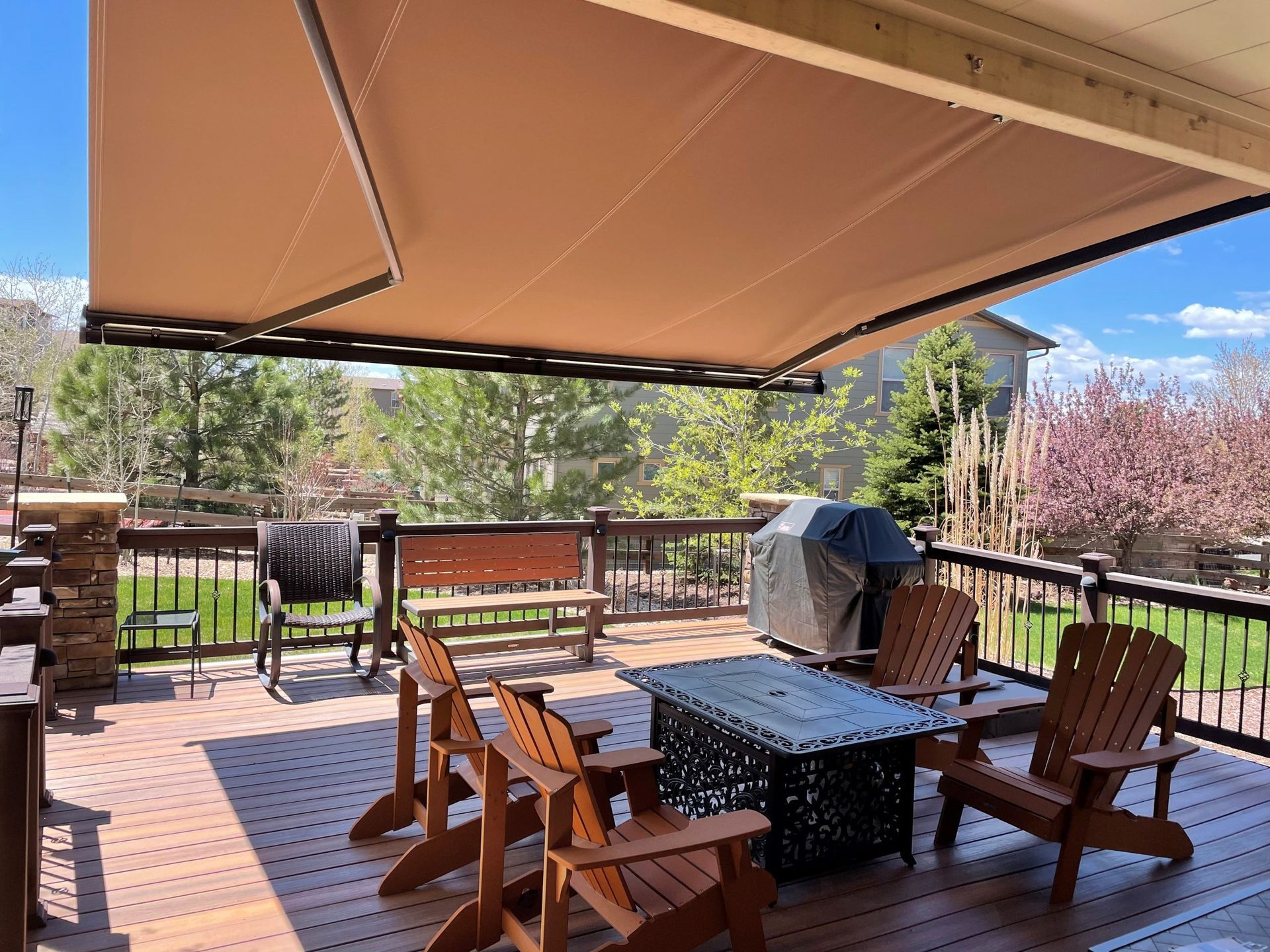 Stylish backyard deck with seating area and awning highlighting 2025 Pacific Northwest home design ideas.