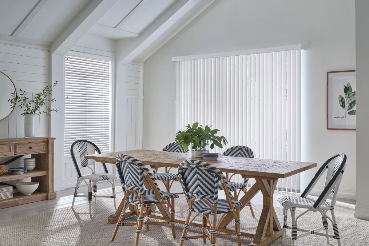Elegant vertical fabric blinds paired with wood dining table and patterned chairs.