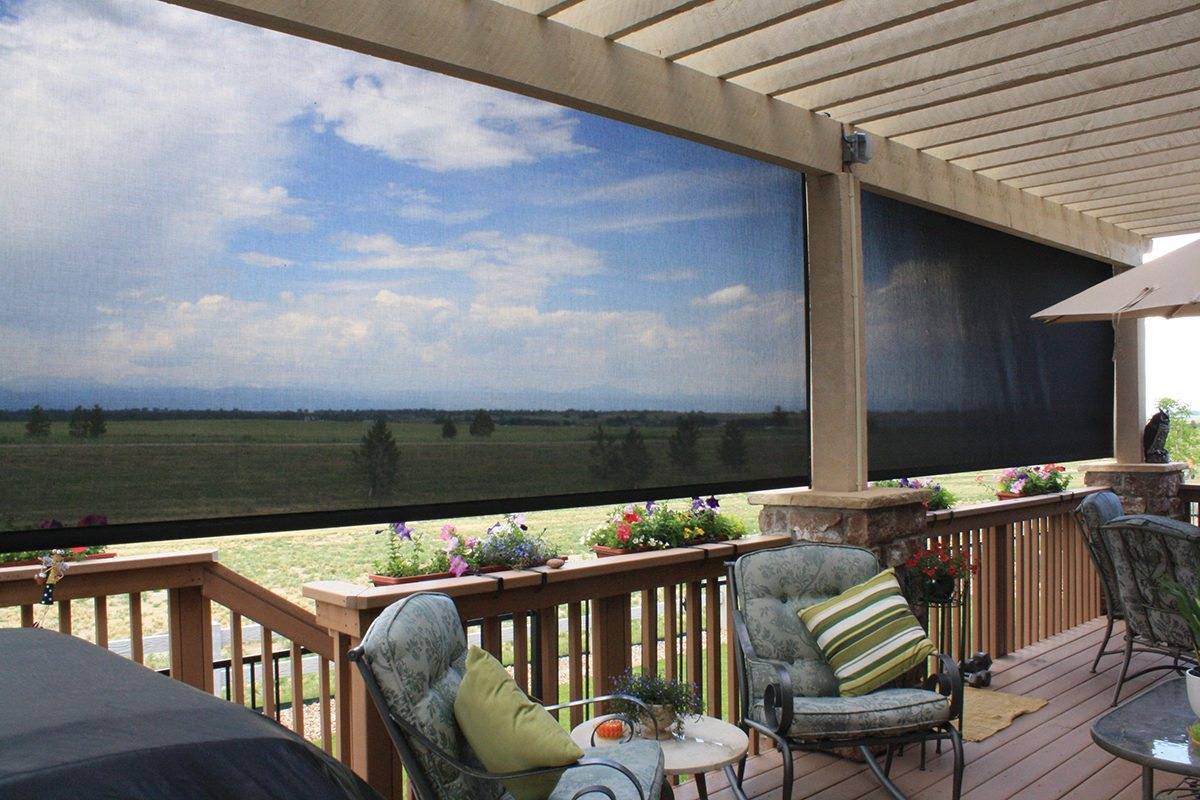 Covered deck with top motorized patio shades providing shade and outdoor comfort with scenic views.