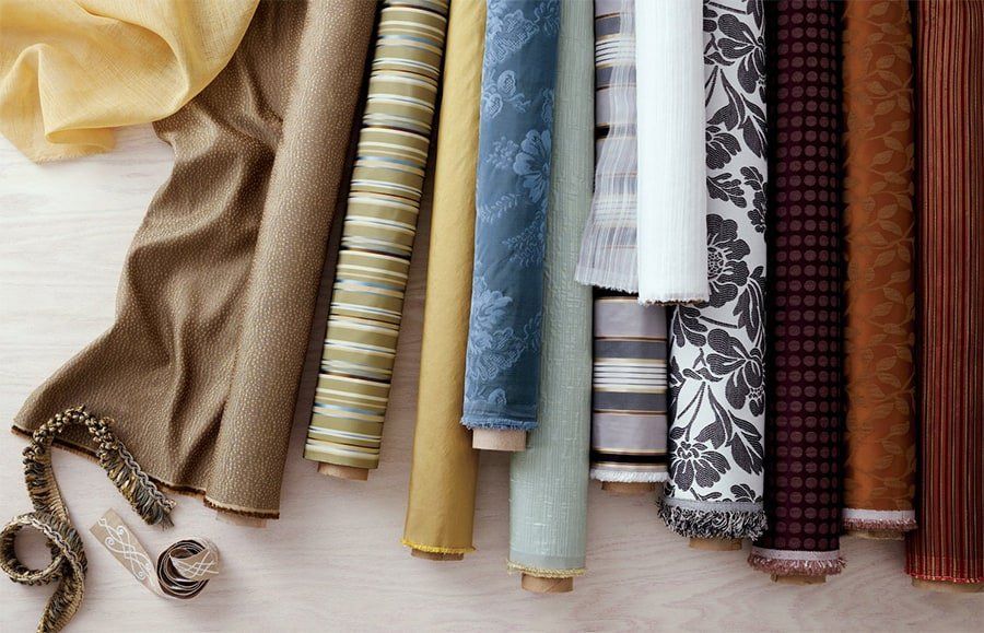 Rolls of durable upholstery fabrics in various colors and patterns, ideal for pet-friendly homes.