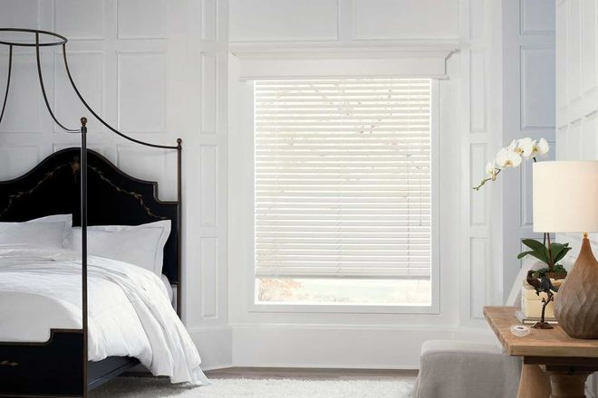 Custom white horizontal blinds in a bright modern bedroom