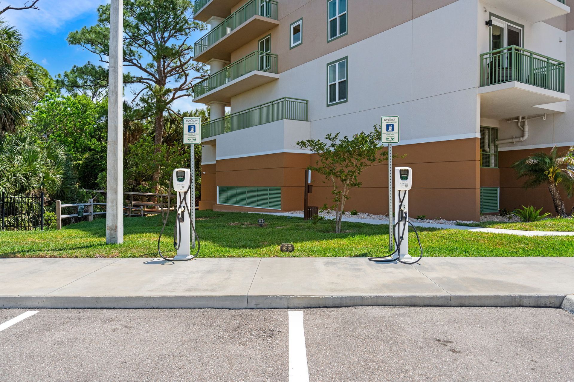 Apartment building entrance with two electric scooter charging stations along the curb