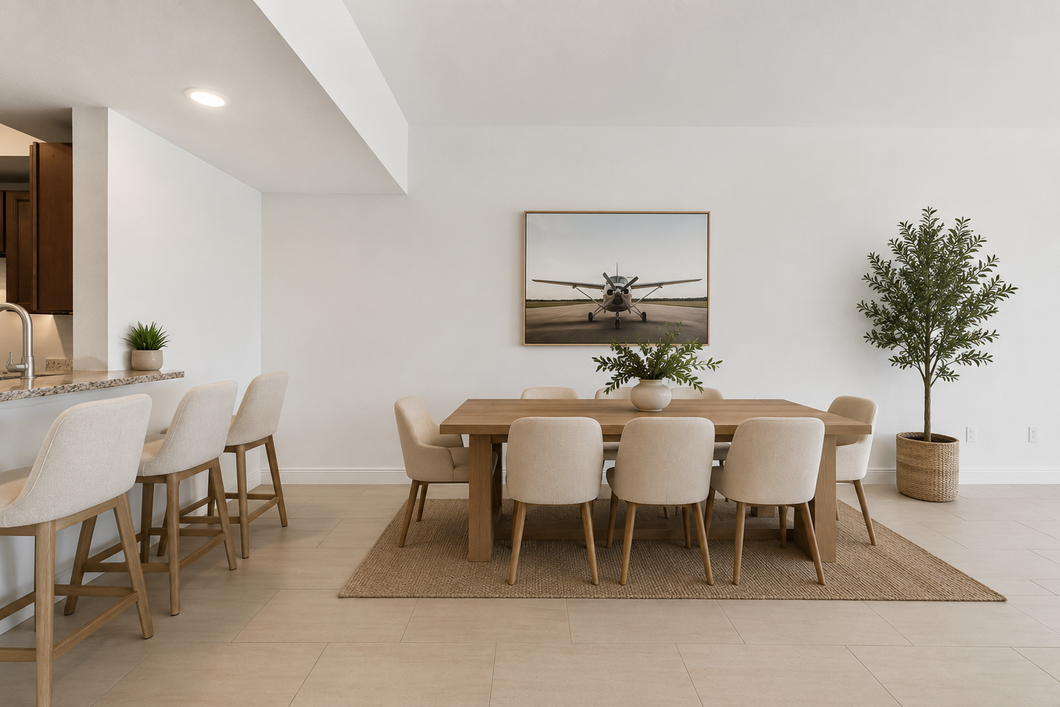 Bright minimalist dining room with a wooden table, beige chairs, woven rug, and potted plants