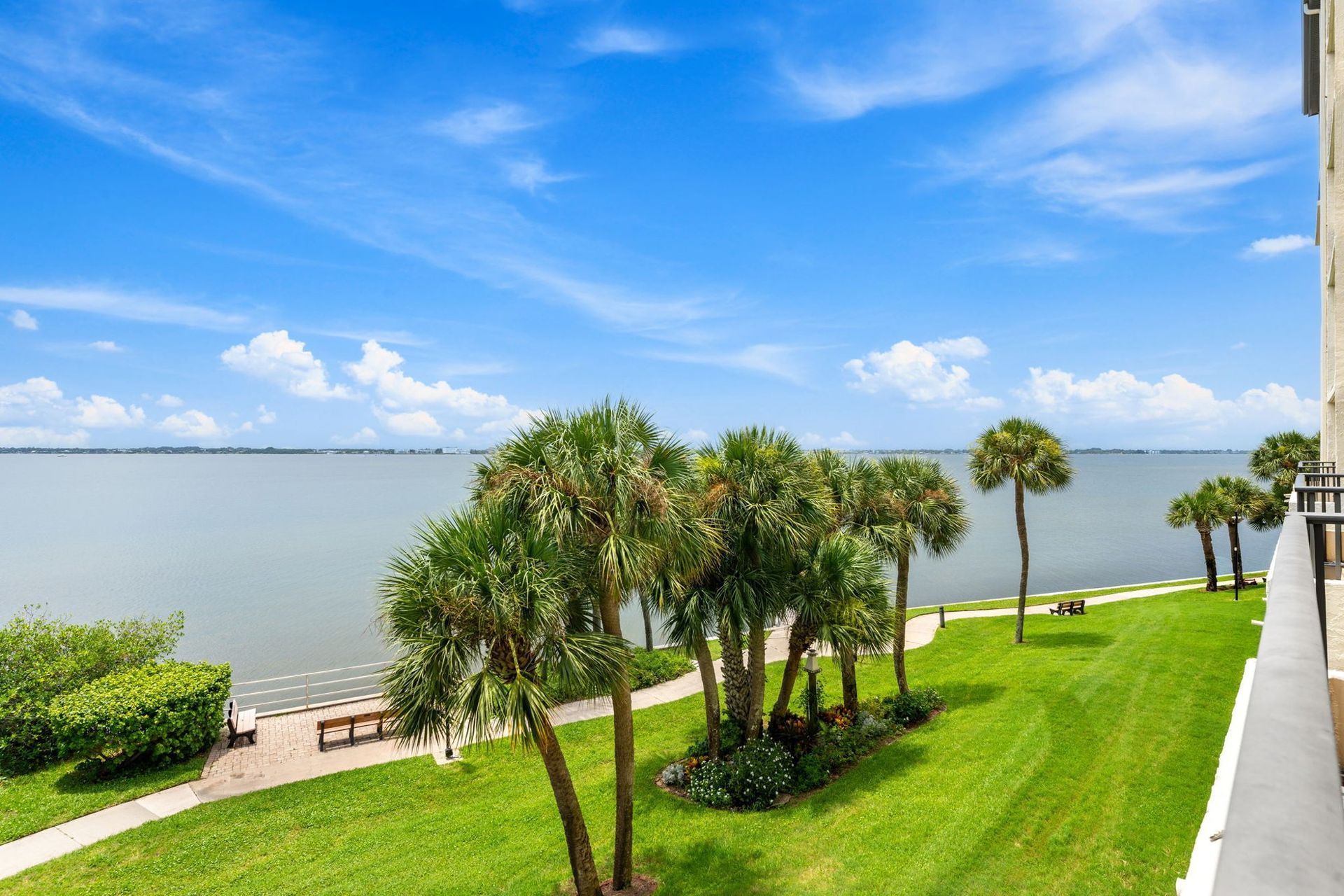 Palm trees and lawn beside the Indian River at a Brevard County condo community.