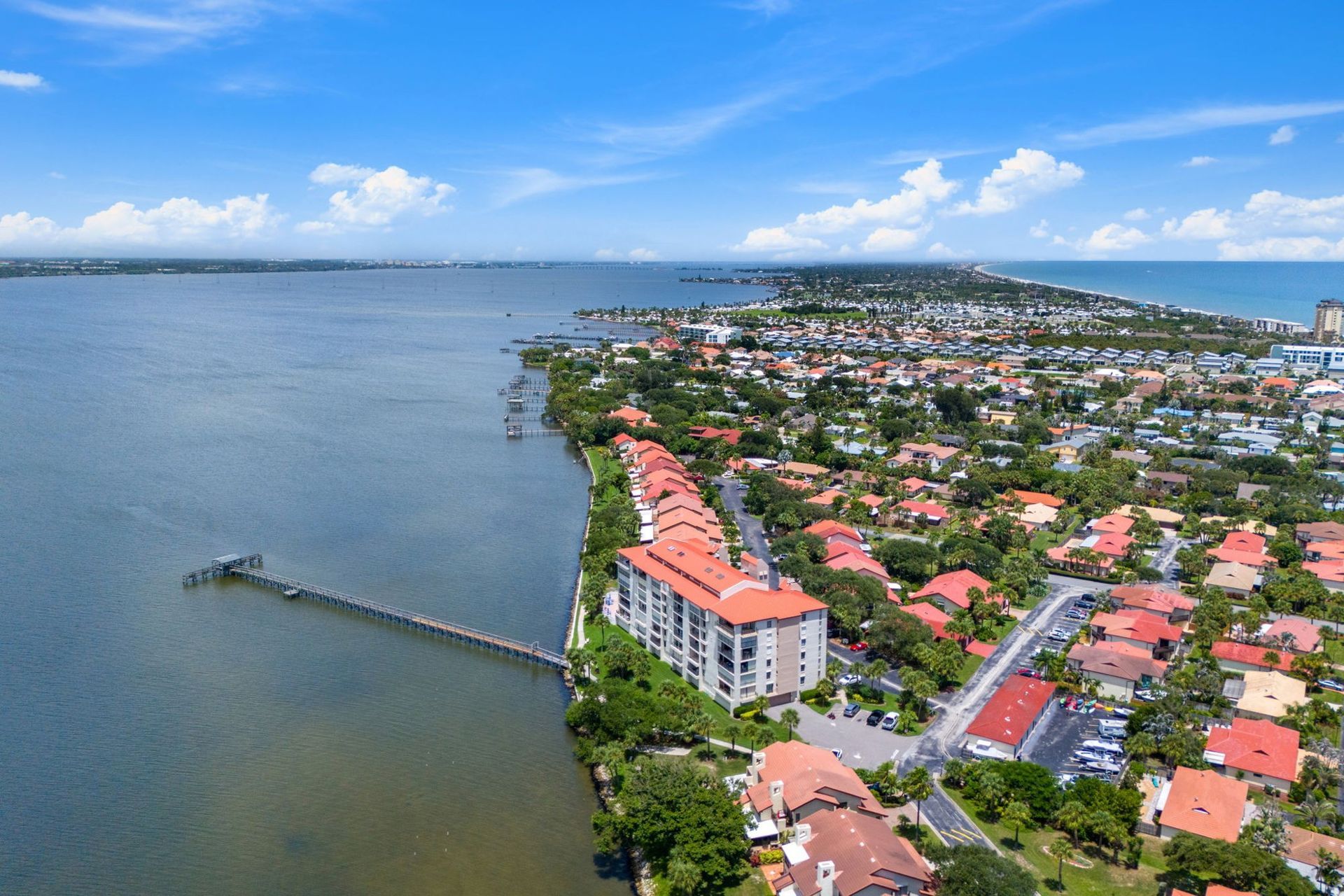 Aerial view of Brevard County waterfront homes and condominiums along the river and a long dock.