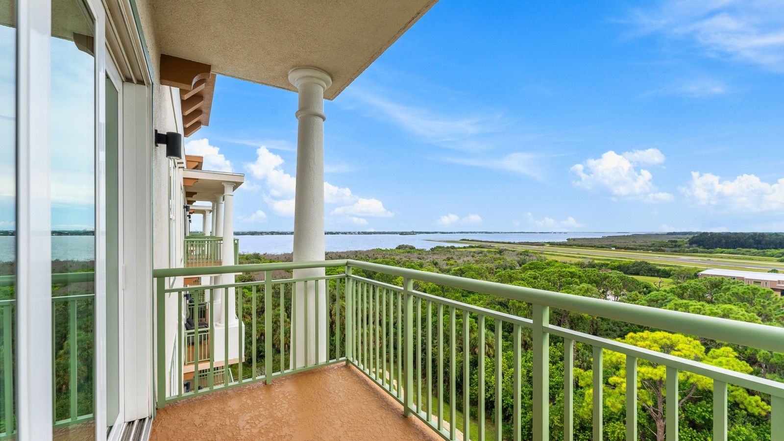 Balcony at Residence 1012 overlooking treetops, the airfield and the river