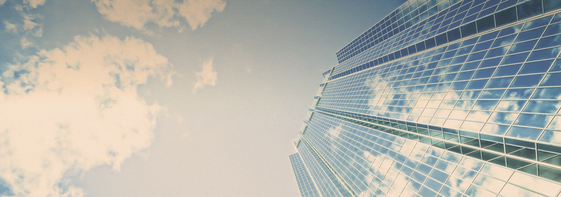 Looking up at a tall building with a blue sky in the background.