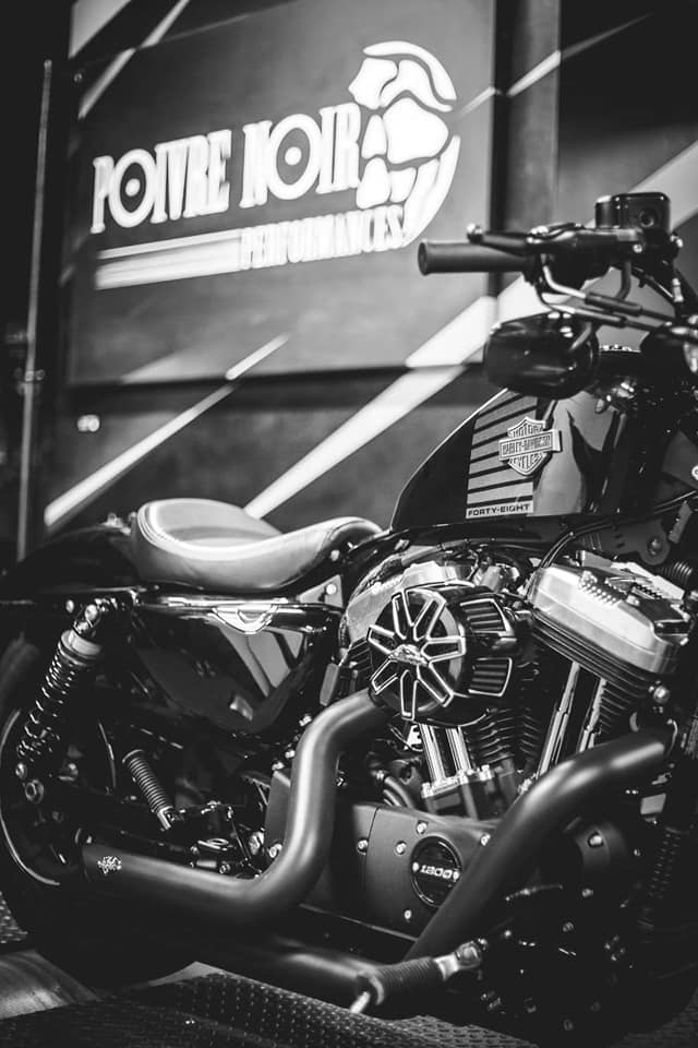Moto Harley-Davidson noire avec pièces personnalisées exposées à l'intérieur.