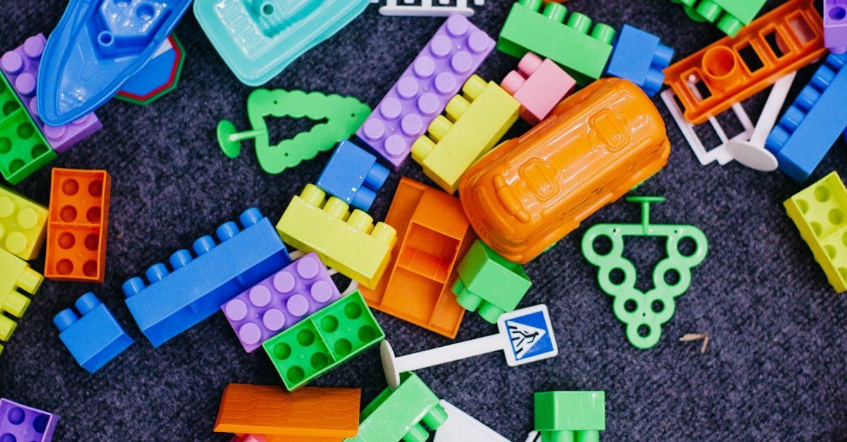 Assorted colorful plastic toy blocks scattered on a dark surface