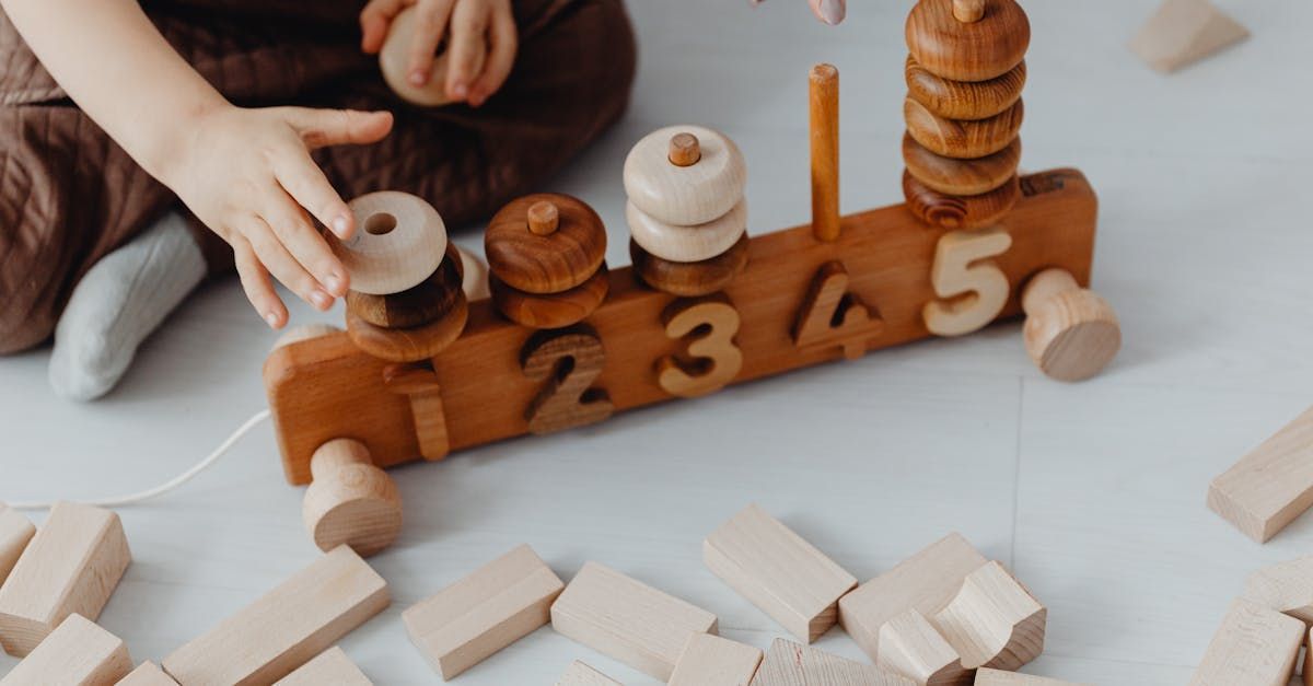Wooden number puzzle blocks with white pegs and scattered pieces on a light surface