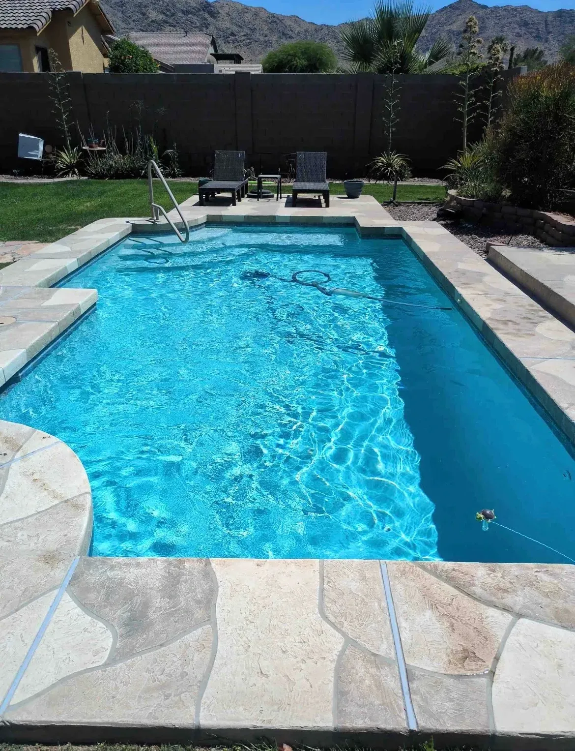 Bright blue rectangular pool with mountain views maintained by AZ Veteran Pools weekly pool service in Phoenix, Arizona