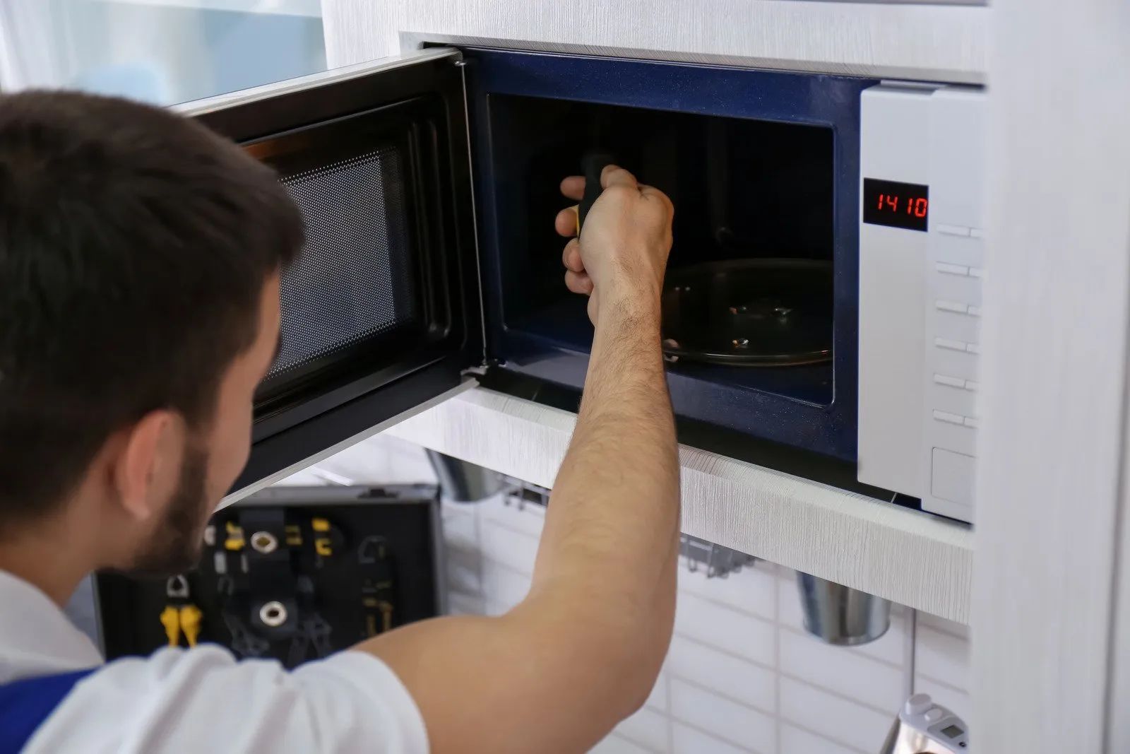 Person loading a sample into a lab machine with an open door and control panel display