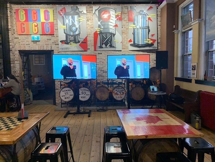 A room with tables and stools and a mural on the wall.