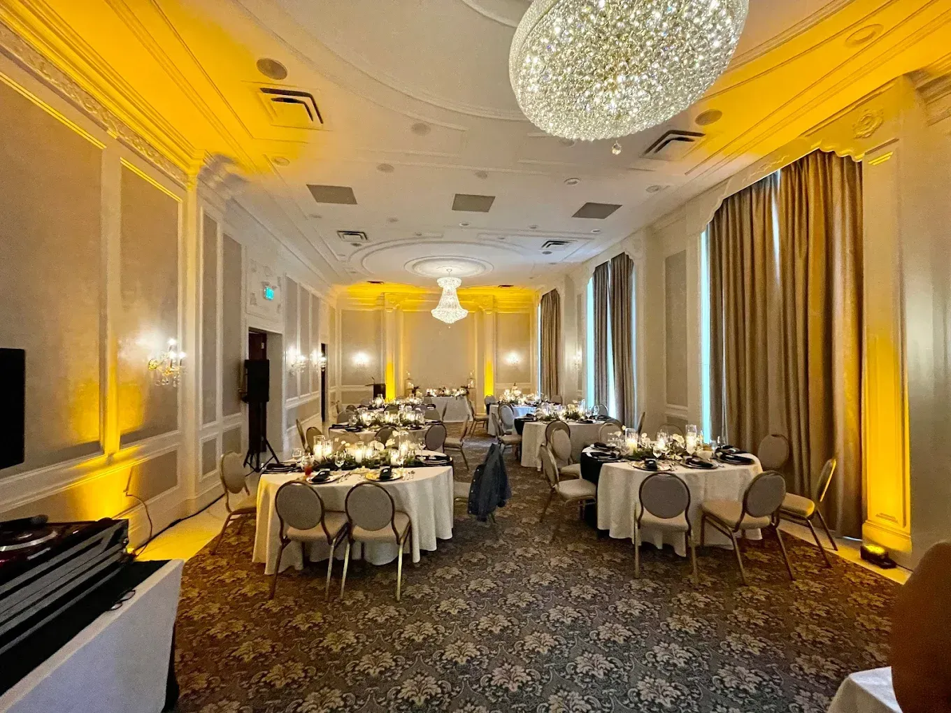 A large room with tables and chairs set up for a wedding reception.