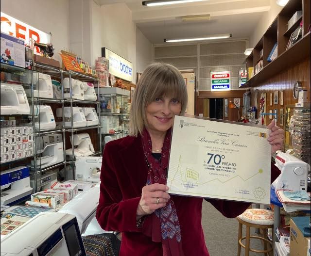 L'immagine rappresenta la signora Brunella, titolare, con in mano un certificato