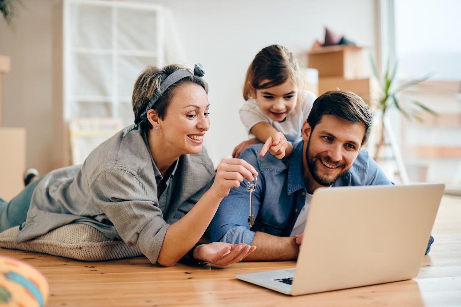 Family using a laptop on the floor in a bright living room