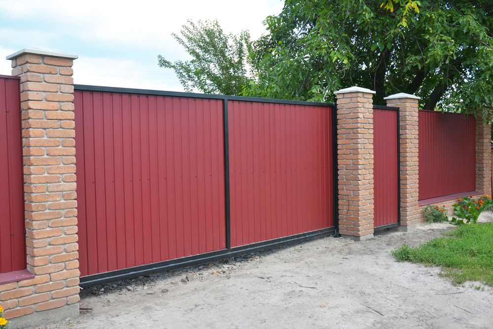 A Red Fence With Brick Pillars Surrounding It — We Do Fencing in Sunshine Acres, QLD