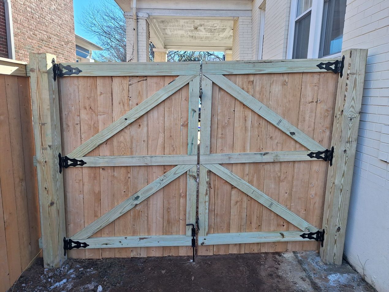 Wooden double gate with hinges.