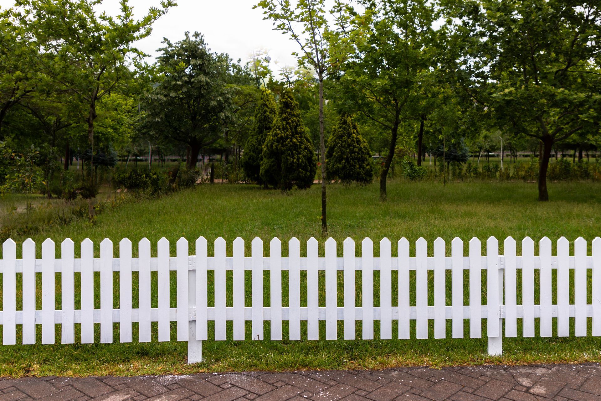 White picket fence in park. White picket fence in park.