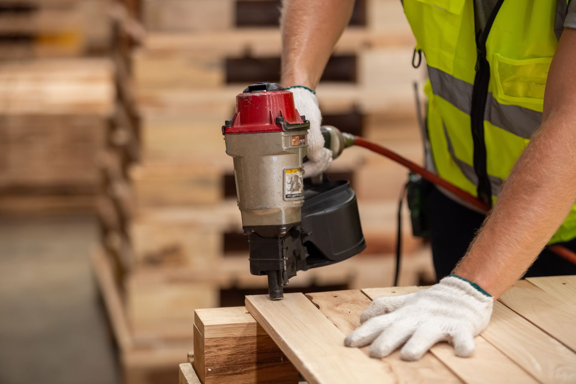 Worker using a coil nailer.