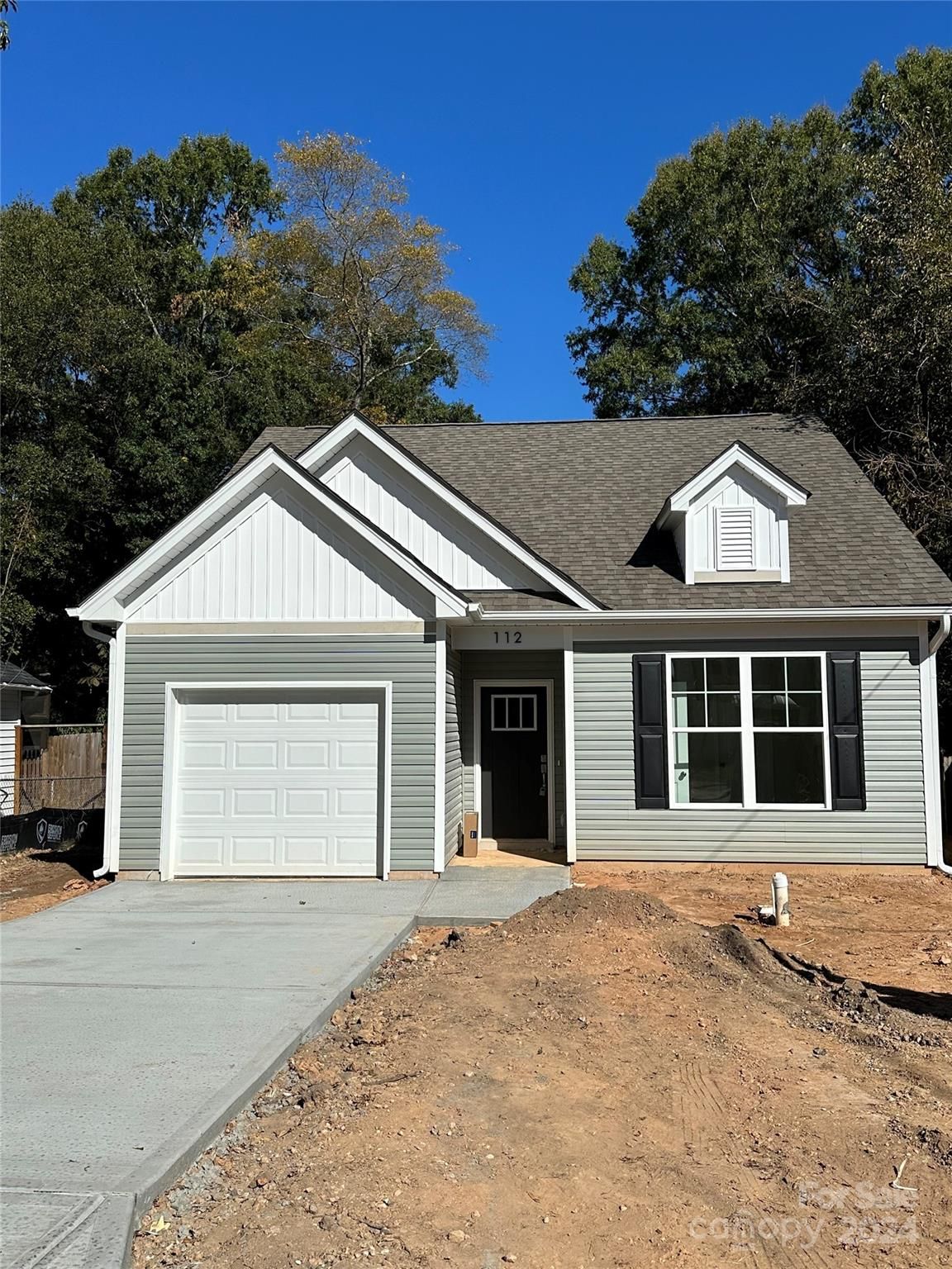 A house with a garage and a driveway is for sale.