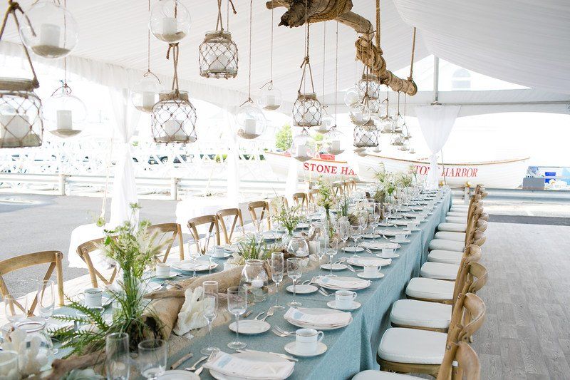 A long table set for a wedding reception with a blue table cloth