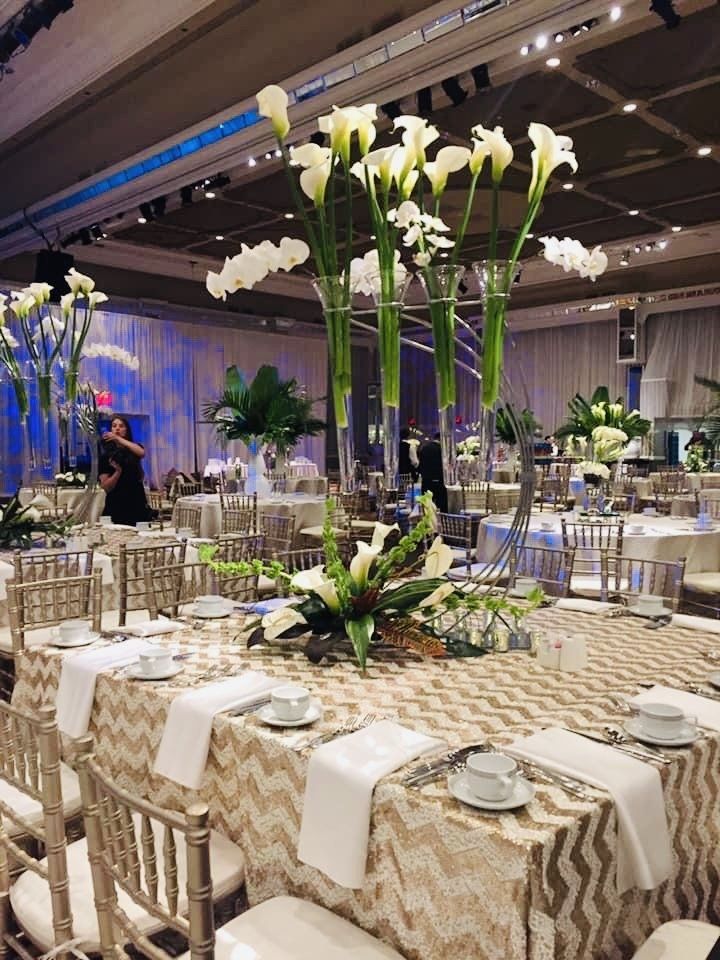 A large room with tables and chairs set up for a wedding reception.