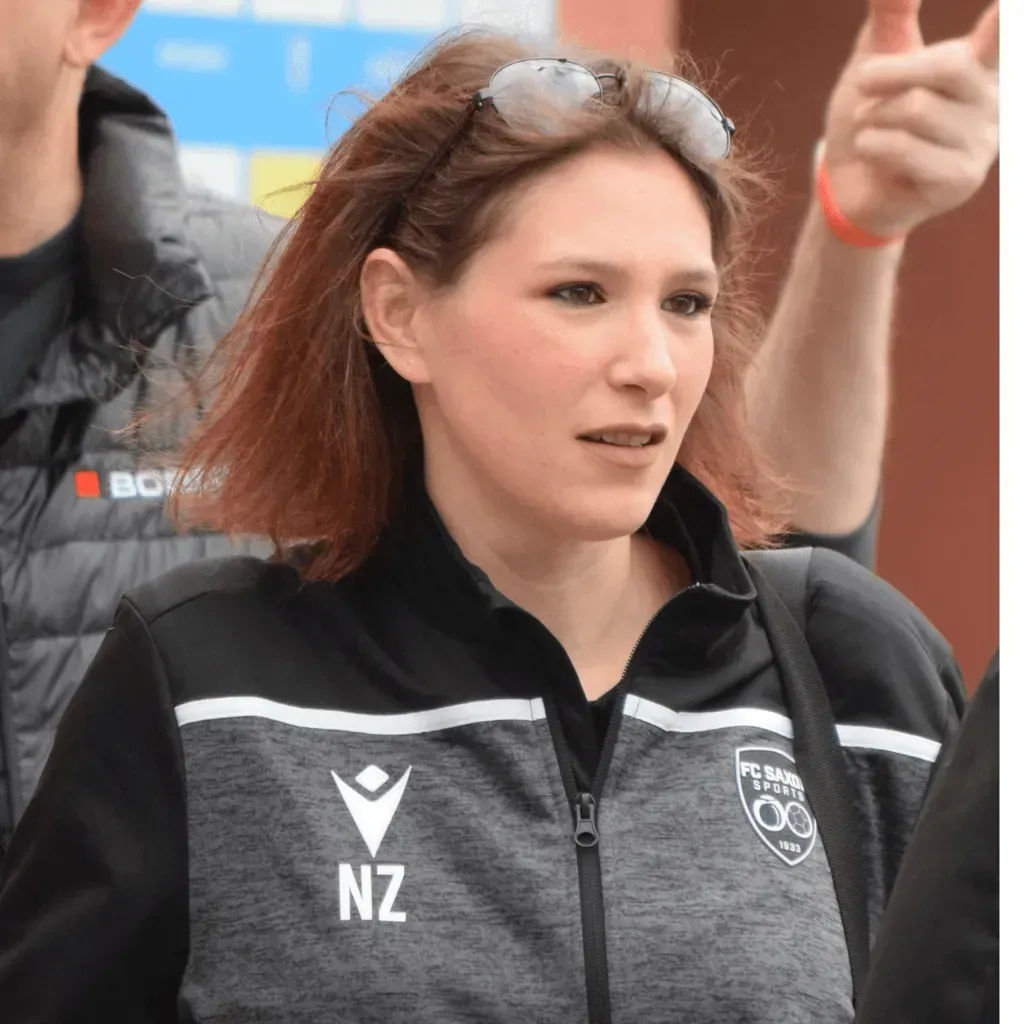 Une femme portant des lunettes de soleil et une veste avec la lettre nz dessus