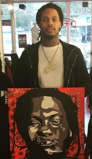 A man is holding a painting of a man 's face