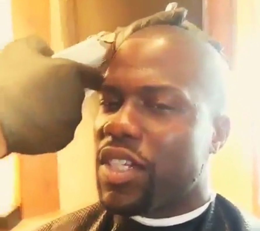 A man with a beard is getting his hair cut by a barber.