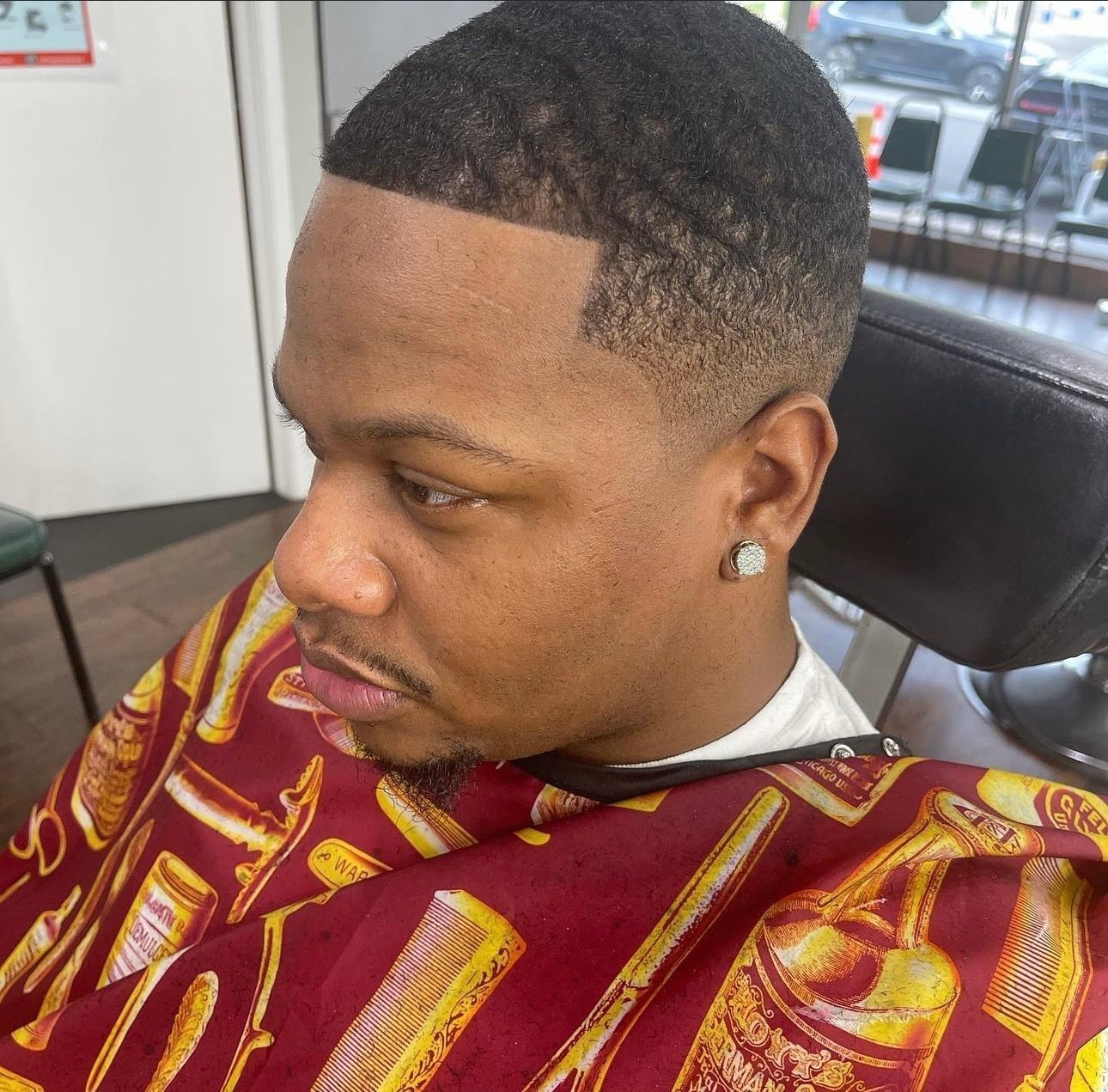 A man is getting his hair cut at a barber shop.